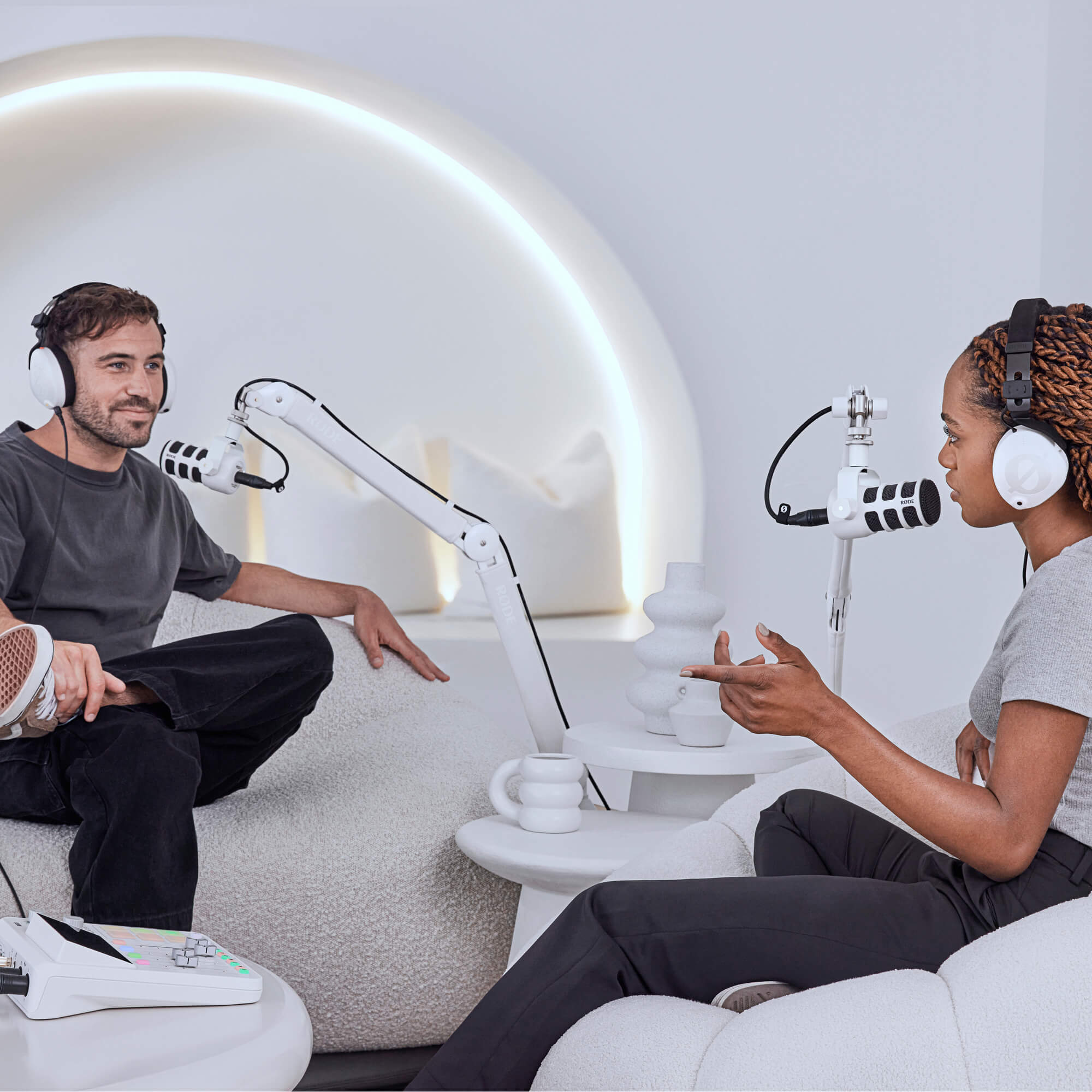 Weißer RØDE PSA1+ Arm und weißes PodMic in einem hellen Podcast-Studio